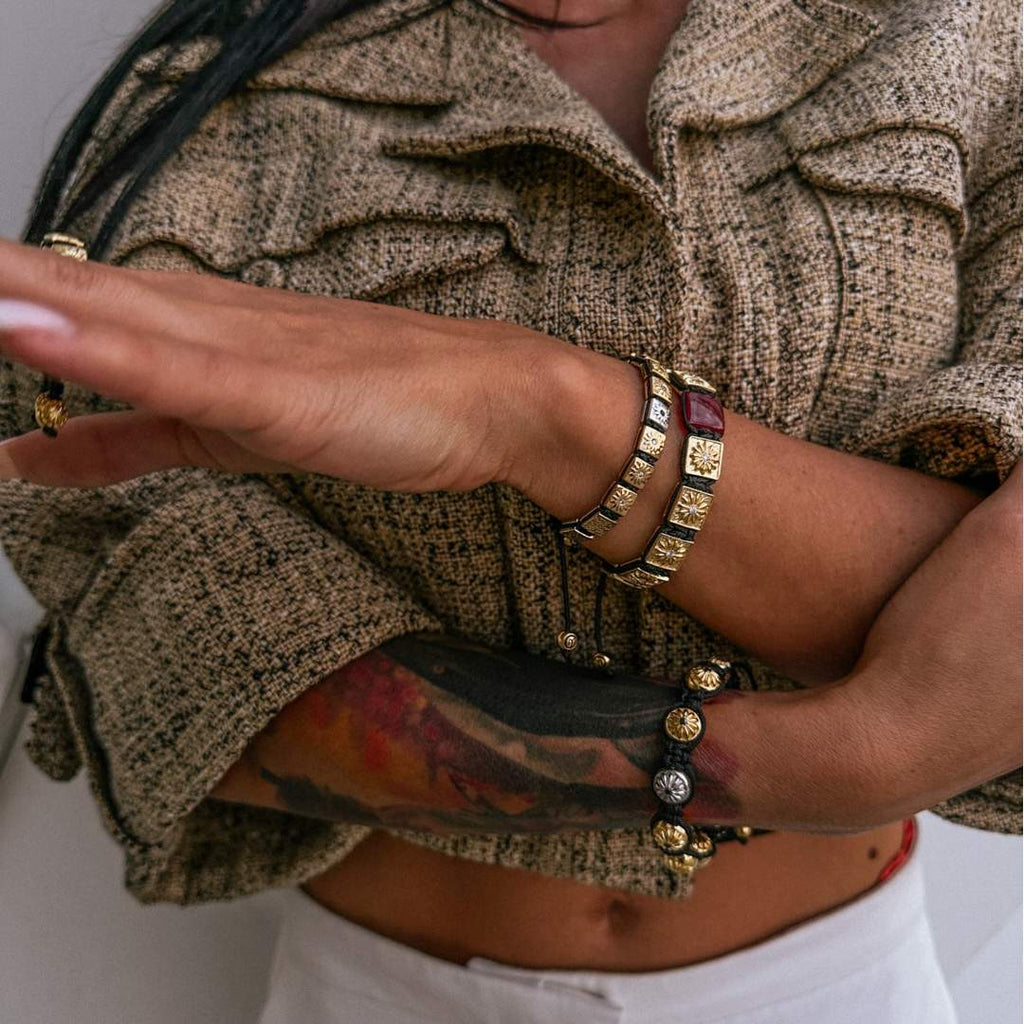 women's hands wearing gold bracelets