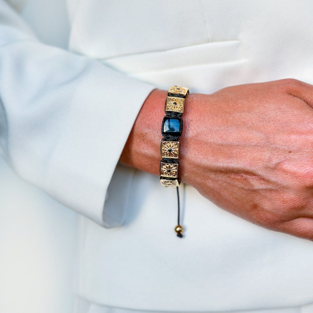 woman with white dress wearing gold macrame bracelet with black stones - the guardian 