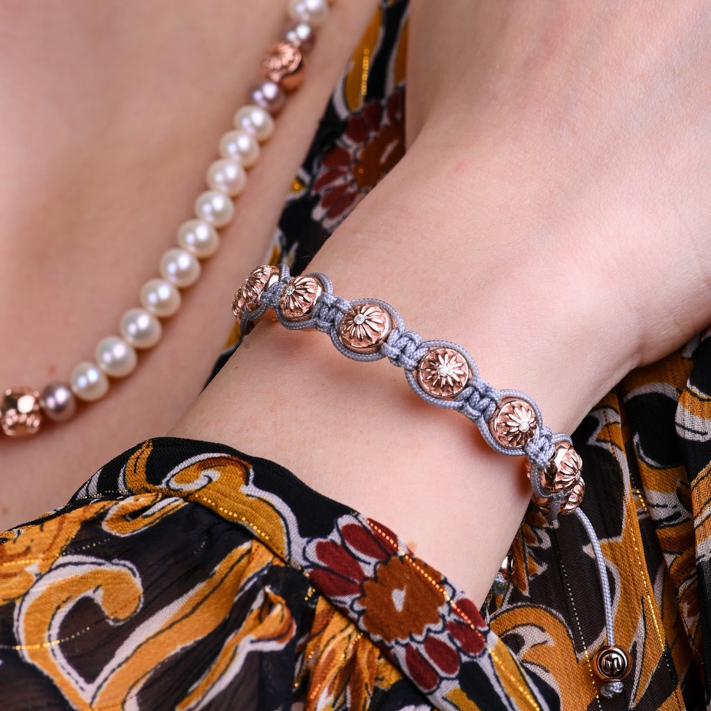 rose gold bracelet on a woman wearing pearl necklace 