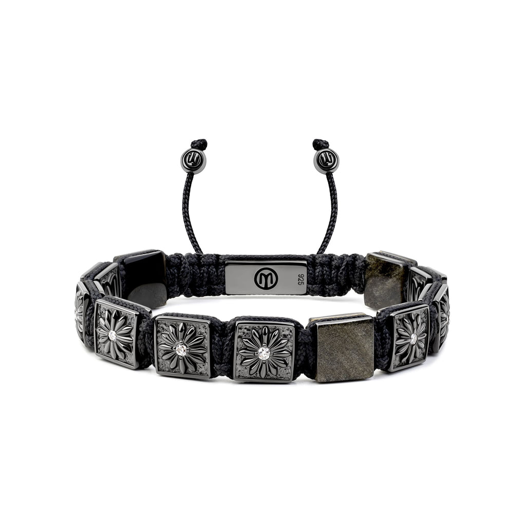 Black braided bracelet with square metal beads on a white background