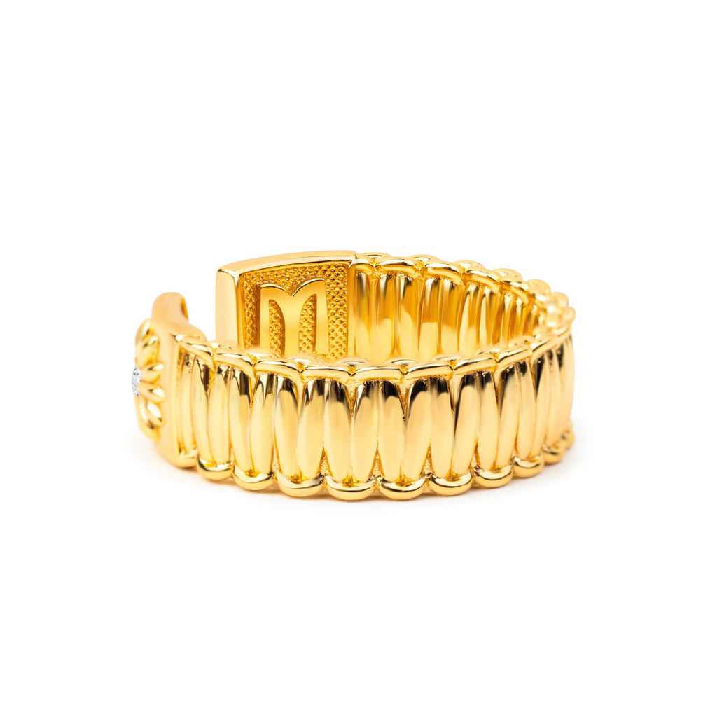 Gold ring with a textured design on a white background