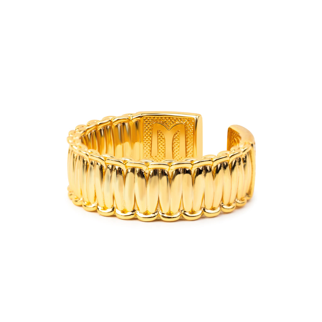 Gold ring with a ribbed design on a white background