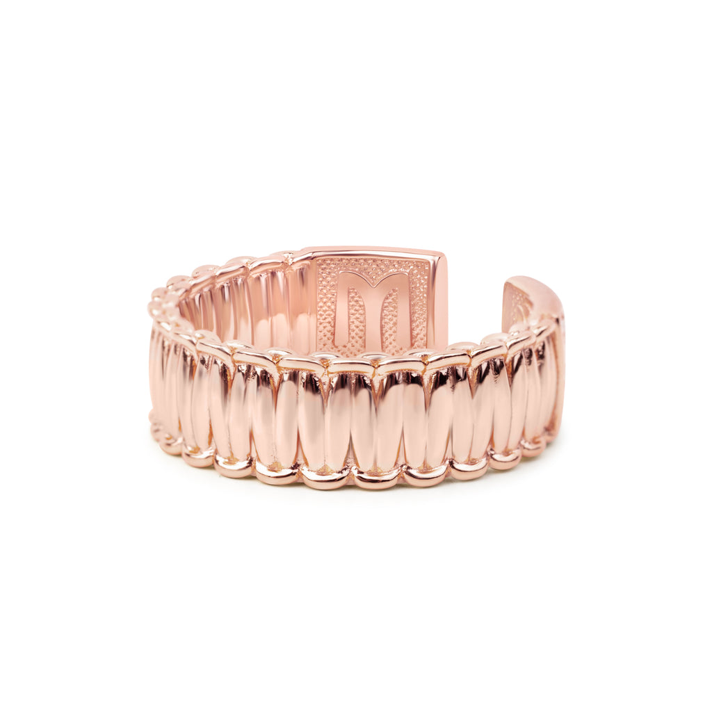 Rose gold ring with textured design on a white background