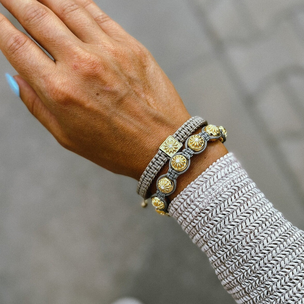 womans hand with two gold macrame bracelets mahigan