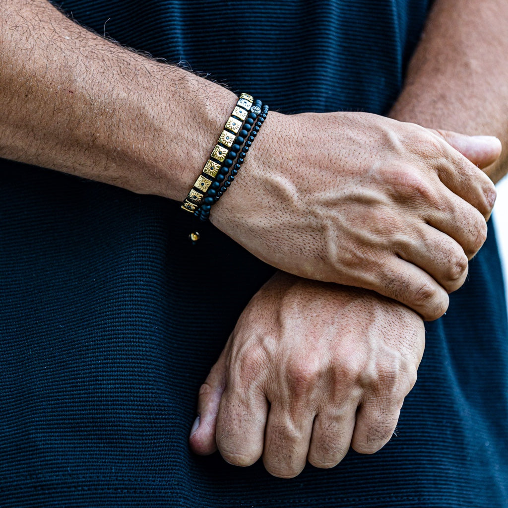 men wearing gold shamballa bracelet with black diamonds