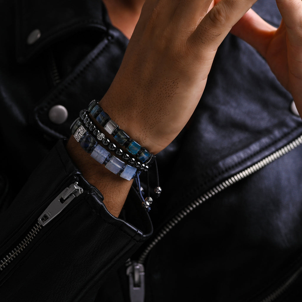 men with leather jacket wearing  bracelet stacks on his hands 