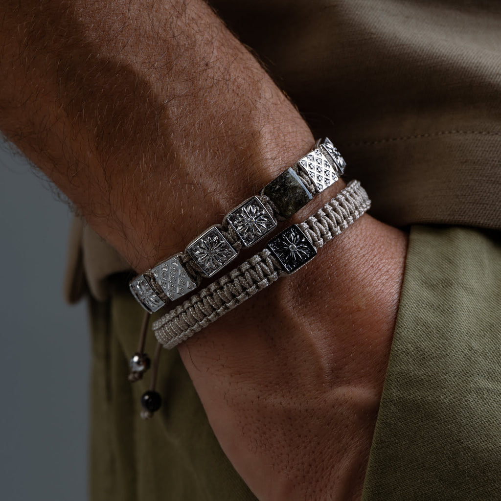 Close-up of a wrist wearing multiple bracelets with intricate designs.