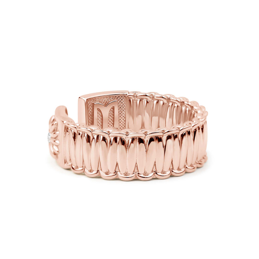 Rose gold ring with a textured design on a white background