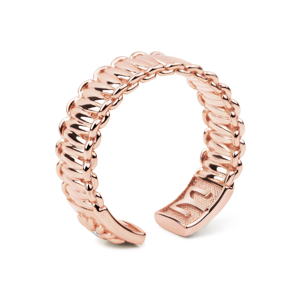 Rose gold ring with a textured design on a white background
