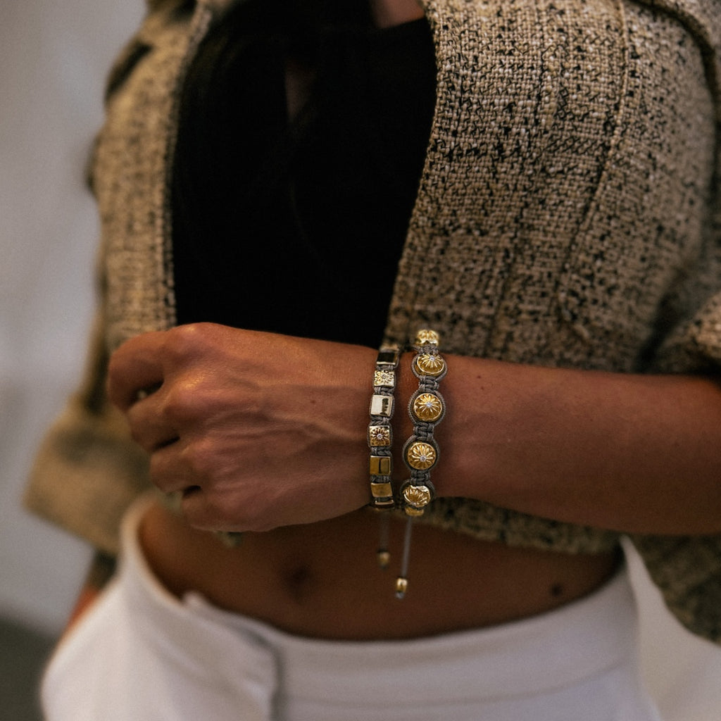 woman wearing two gold macrame bracelets 