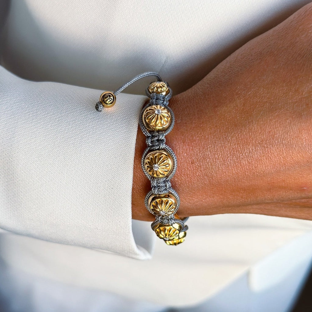 gold bracelet with grey string and white stones 