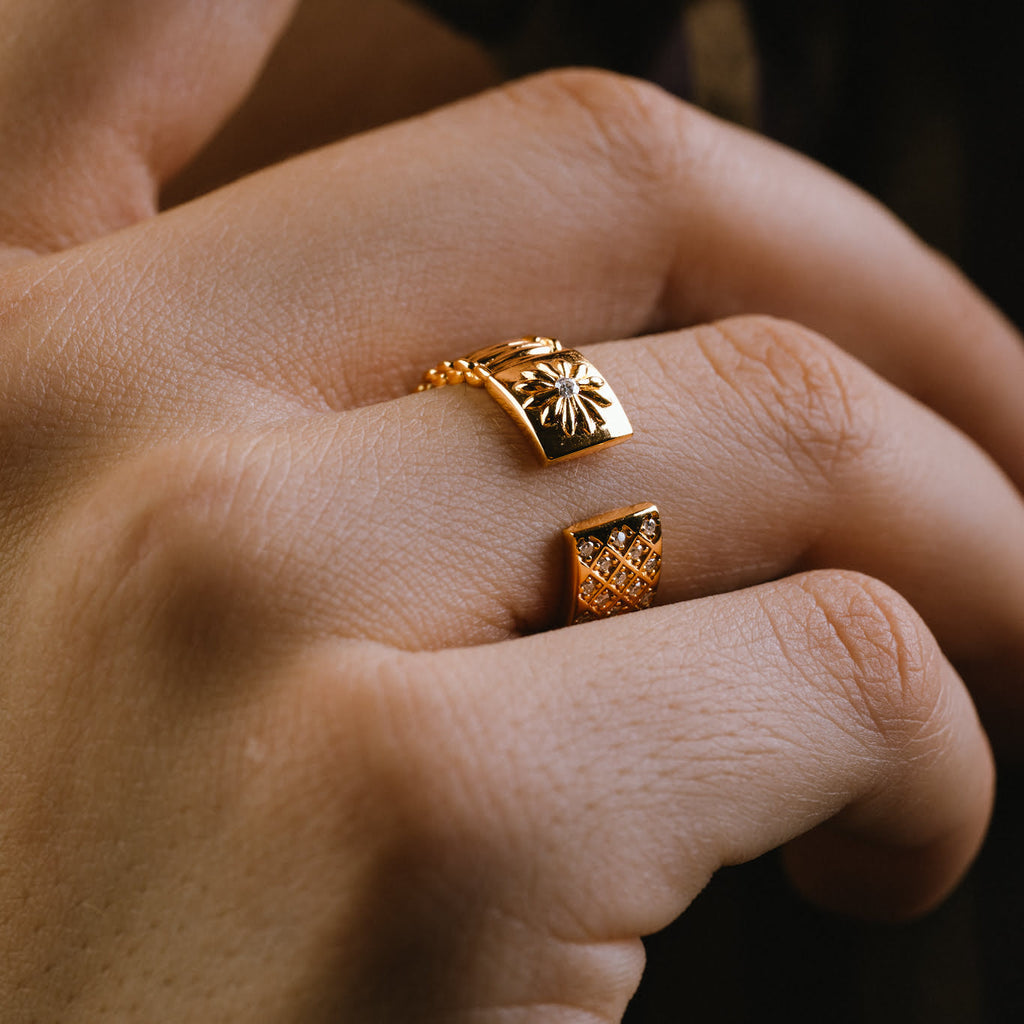 Close-up of a hand wearing a gold ring with white diamonds.